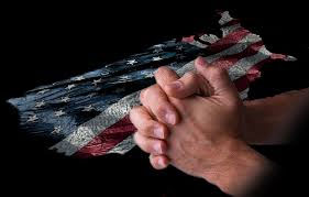 Hands clasped over American Flag