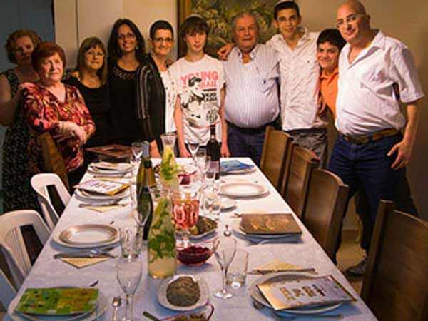 Jewish family in Israel sitting down to enjoy Passover dinner.