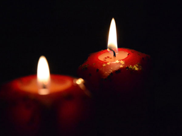 Red Advent candles lit in the dark.