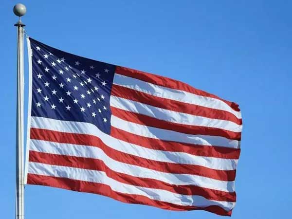 American Flag Flying top of wooden pole.