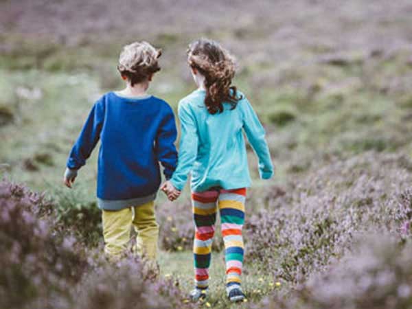 Two kids holding hands in friendship.