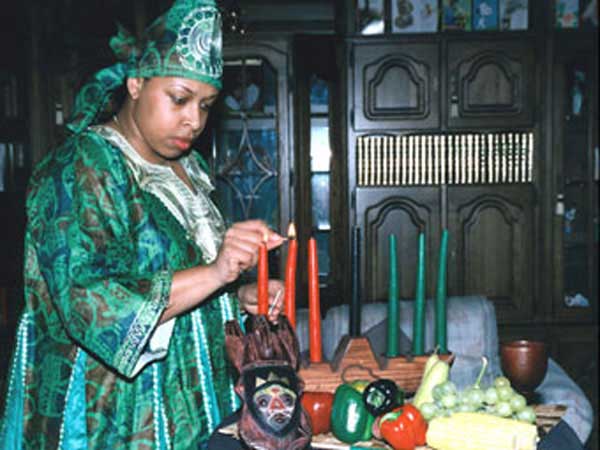 Kwanzaa Sargent in US Air Base Wing lights candle in the Kinara.