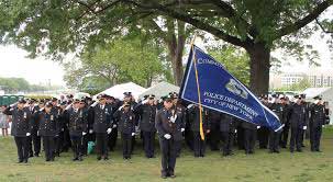 Police Officers saluting and holding flag