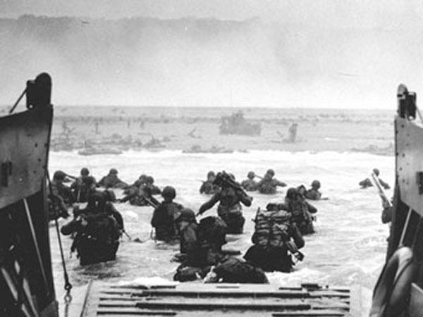 United States soldiers exiting landing craft in Normandy on June 6, 1944.